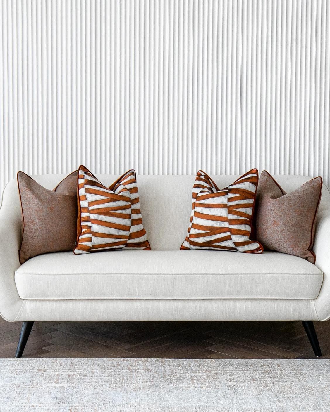Alani Bundle cushion in orange, white and red, shown in a lifestyle front view as image 4