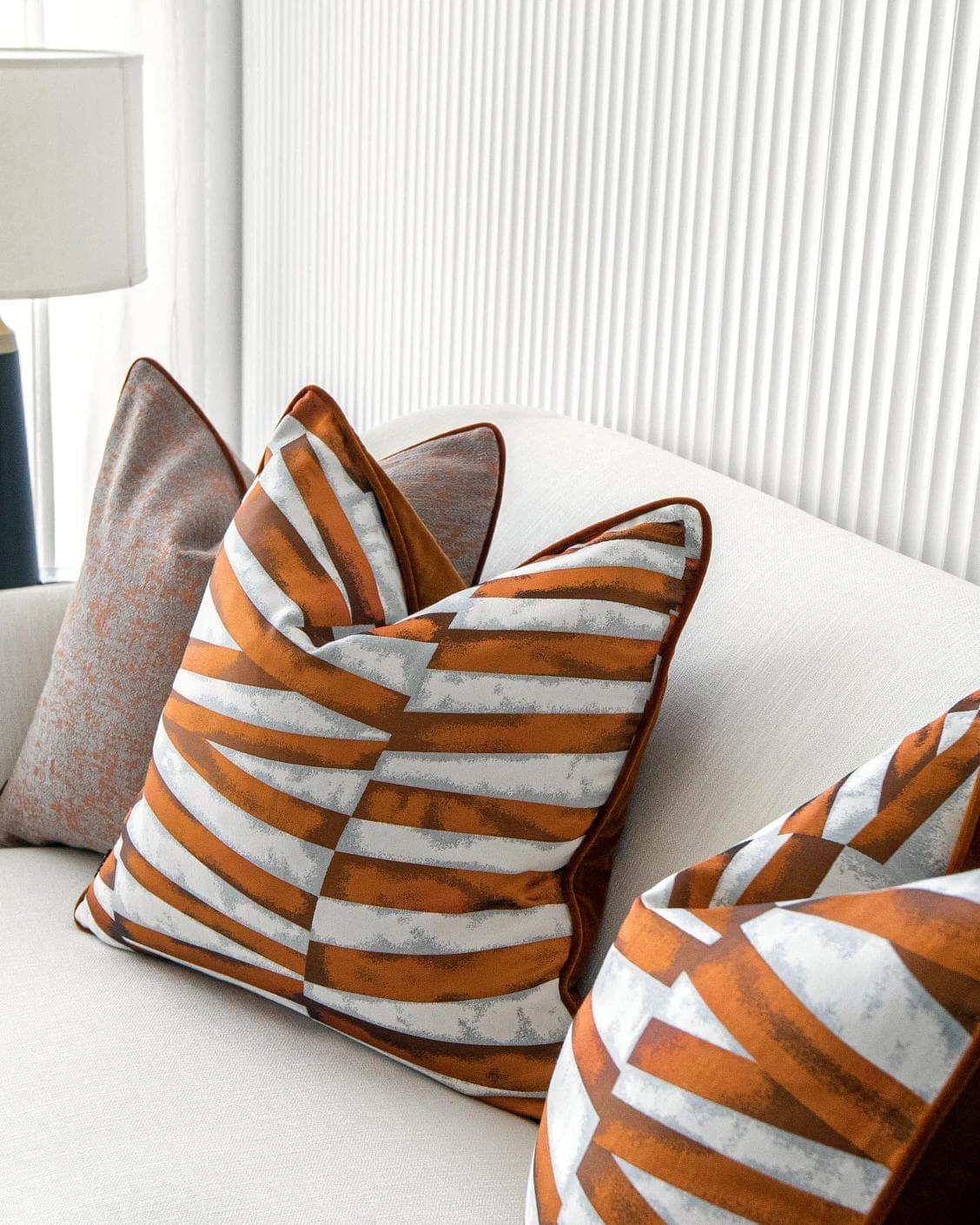 Alani Bundle cushion in orange, white and red, shown in a lifestyle right view as image 5