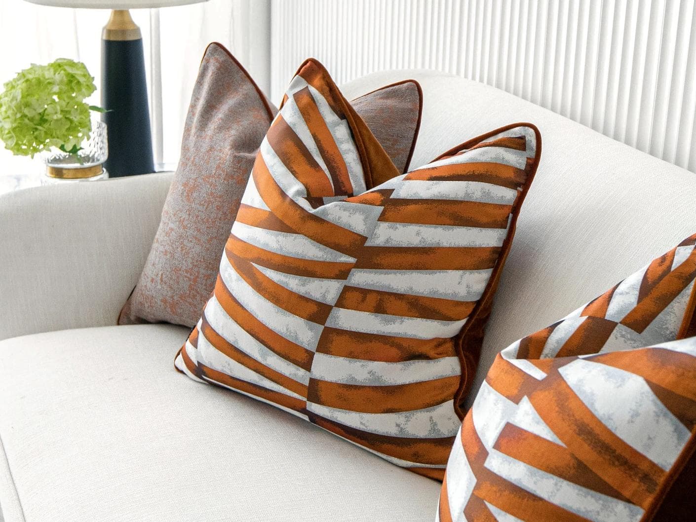 Alani Bundle cushion in orange, white and red, shown in a lifestyle right view as image 5