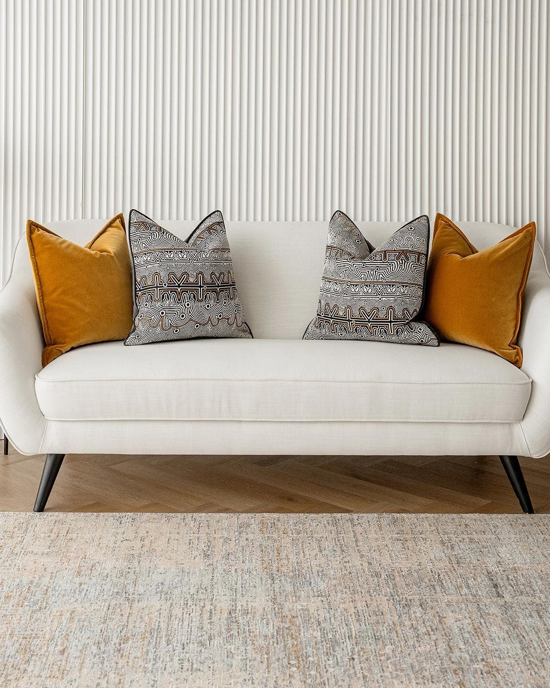 Adin Bundle cushion in orange, black and silver, shown in a lifestyle front view as image 4