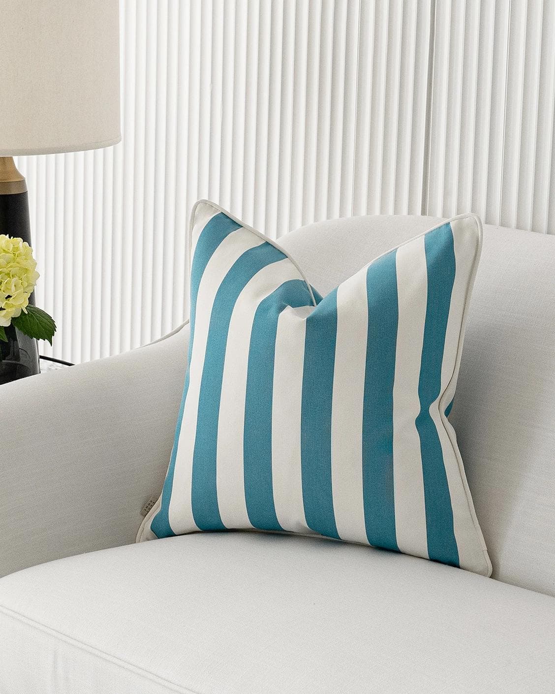 Aelia Azure cushion in blue and soft ivory, shown in a lifestyle front view as image 4