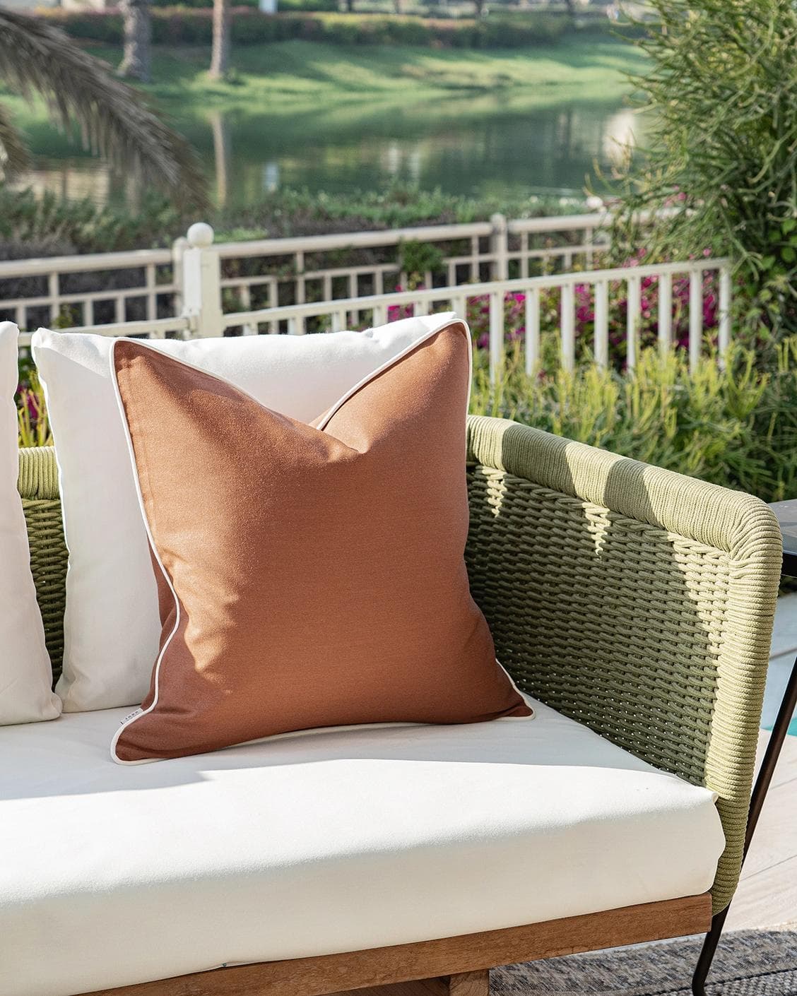 Aelia Clay cushion in rust, shown in a lifestyle left view as image 2