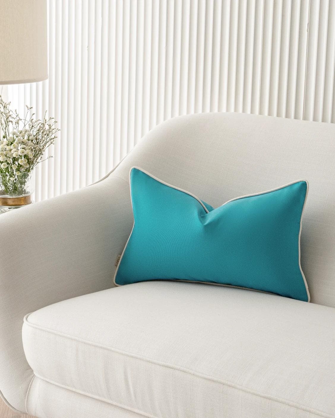 Aelia Sky II cushion in coral and blue, shown in a lifestyle front view as image 5