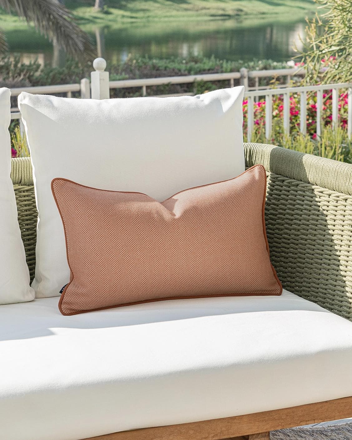 Aelia Tangelo II cushion in rust, shown in a lifestyle left view as image 2