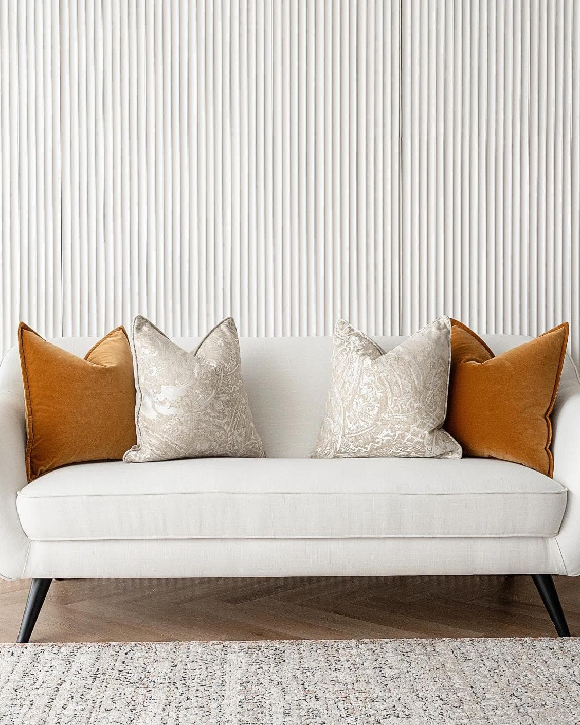 Amiya Bundle cushion in orange, beige and silver, shown in a lifestyle front view as image 4