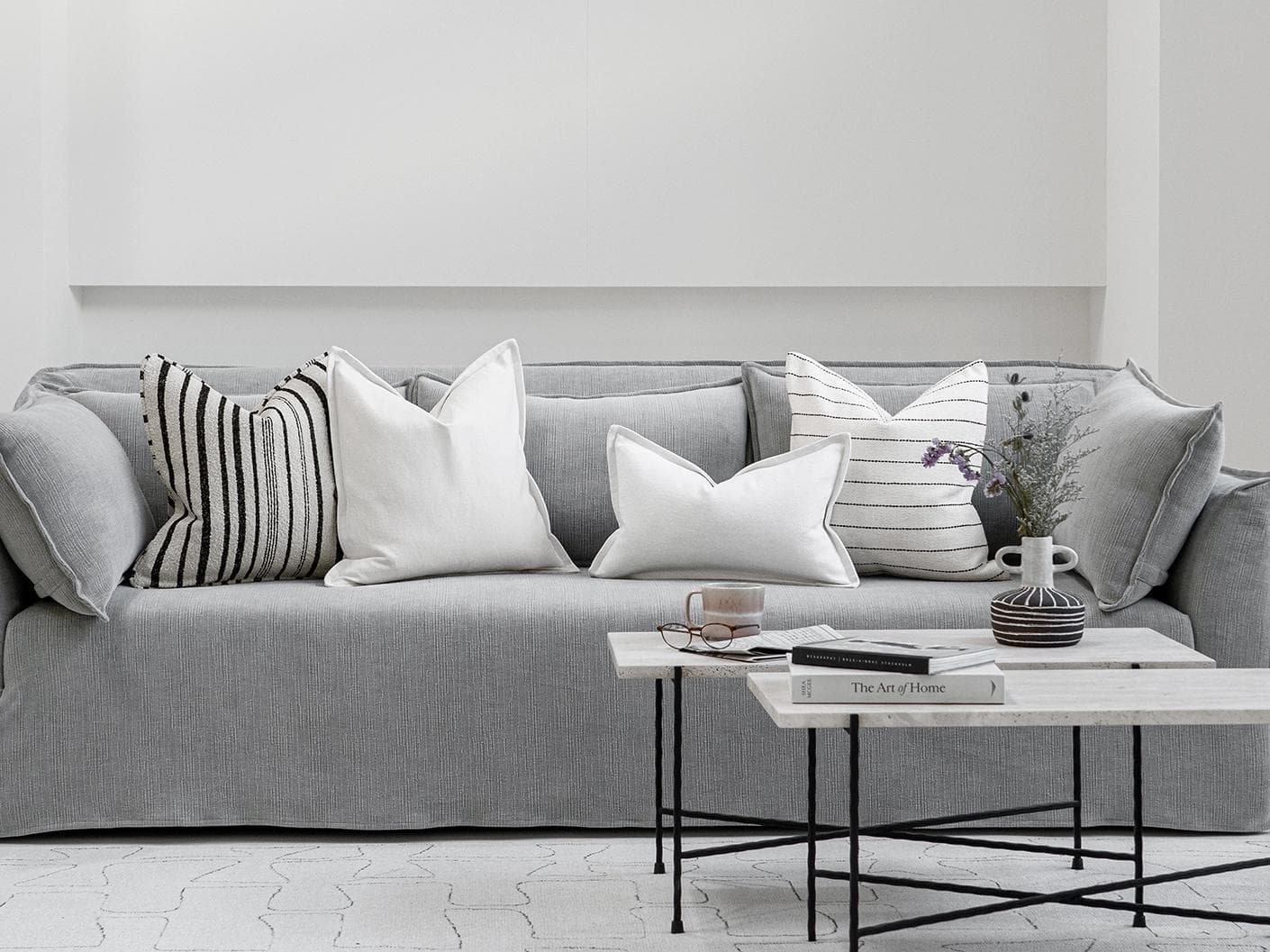 Amshi Bundle cushion in ivory, white and charcoal, shown in a lifestyle front view as image 4