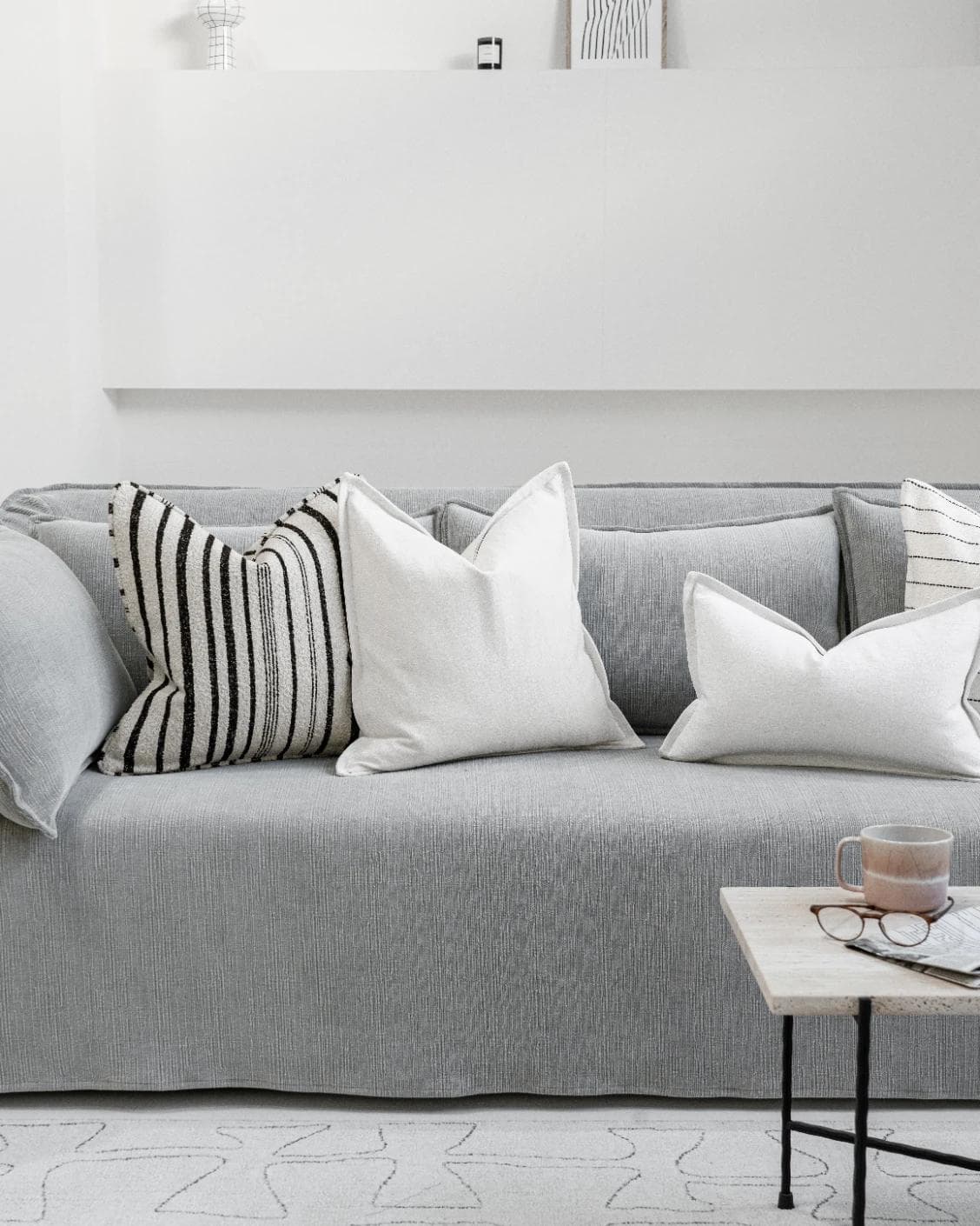 Amshi Bundle cushion in ivory, white and charcoal, shown in a lifestyle front view as image 6