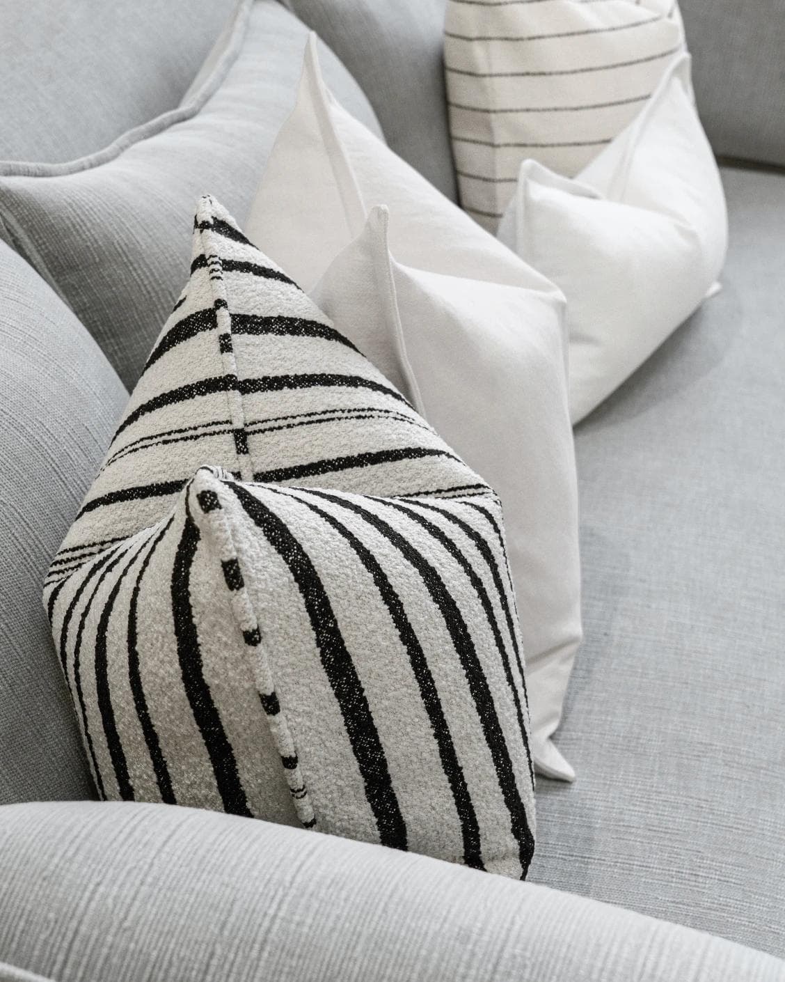 Amshi Bundle cushion in ivory, white and charcoal, shown in a lifestyle left view as image 7