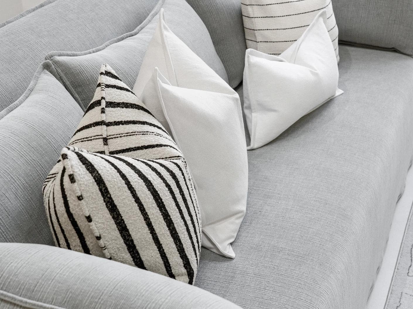 Amshi Bundle cushion in ivory, white and charcoal, shown in a lifestyle top view as image 8
