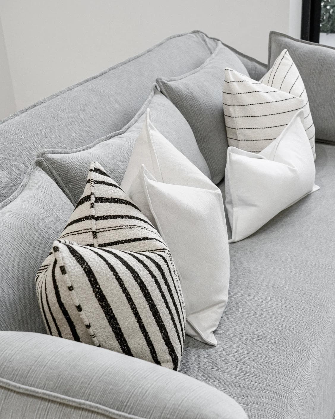 Amshi Bundle cushion in ivory, white and charcoal, shown in a lifestyle top view as image 8
