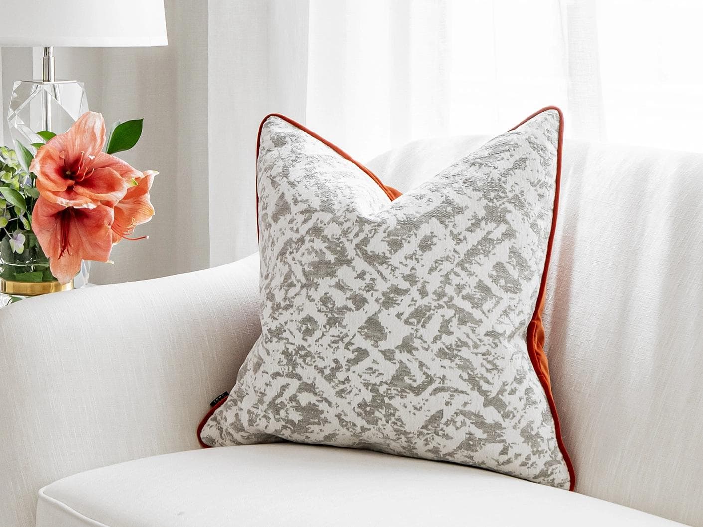 Arcie Tangelo cushion in white, grey and orange, shown in a lifestyle right view as image 1