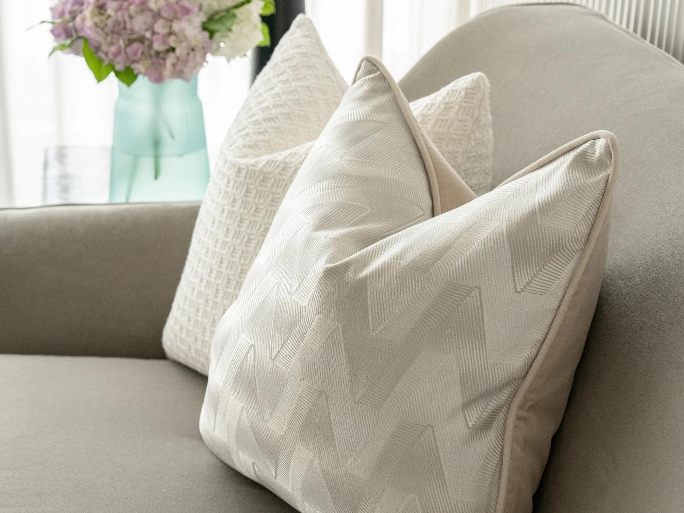 Aynura Bundle cushion in white, beige and silver, shown in a lifestyle front view as image 4