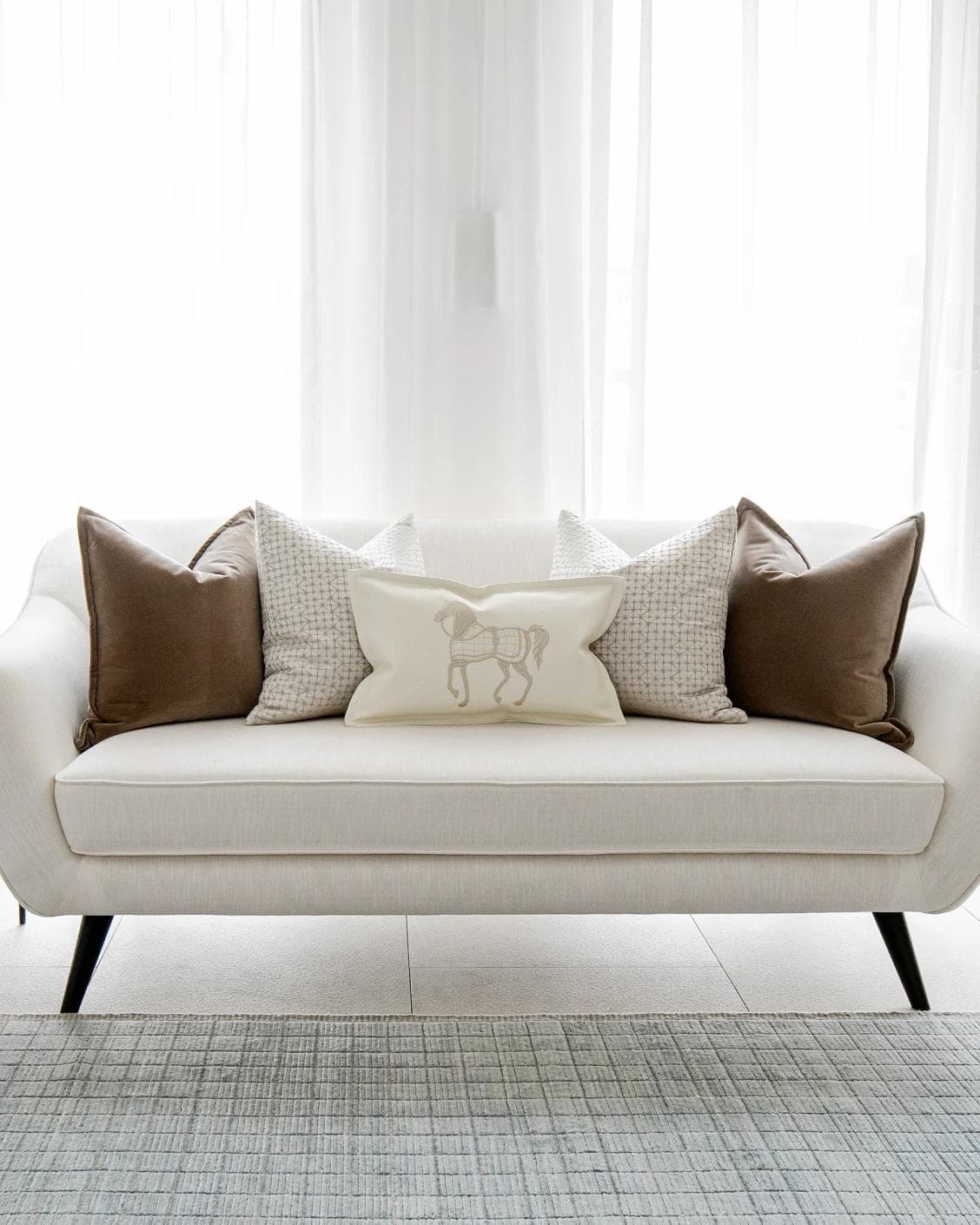 Lina Bundle cushion in brown, silver and white, shown in a lifestyle front view as image 4