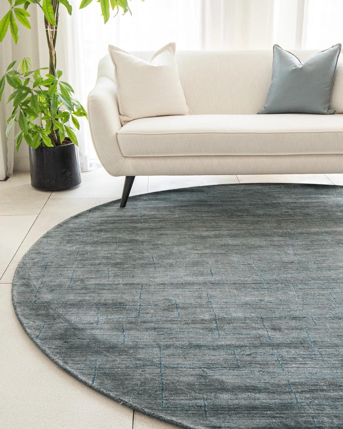 Caleb Ashton Round carpet in grey, teal and blue, shown in a lifestyle front view