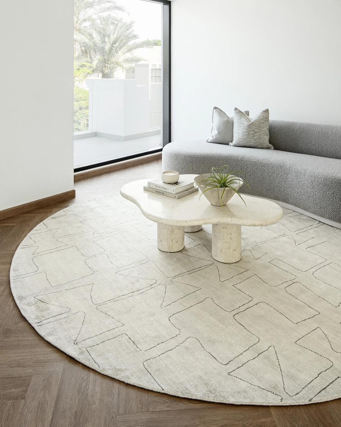 Caleb Ebony Round carpet in pearl and grey, shown in a lifestyle right view