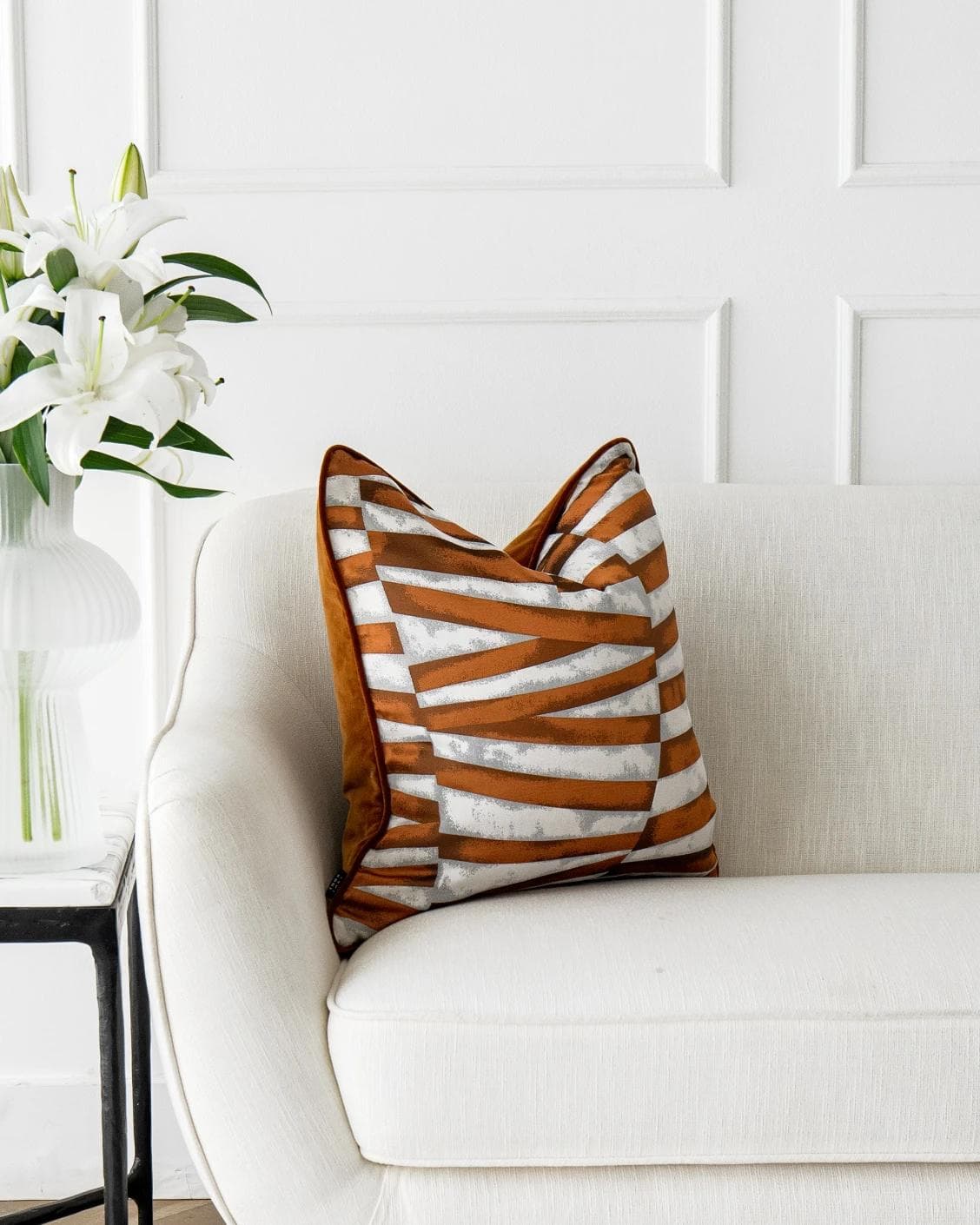 Carlie Hodler cushion in orange and white, shown in a lifestyle left view as image 4