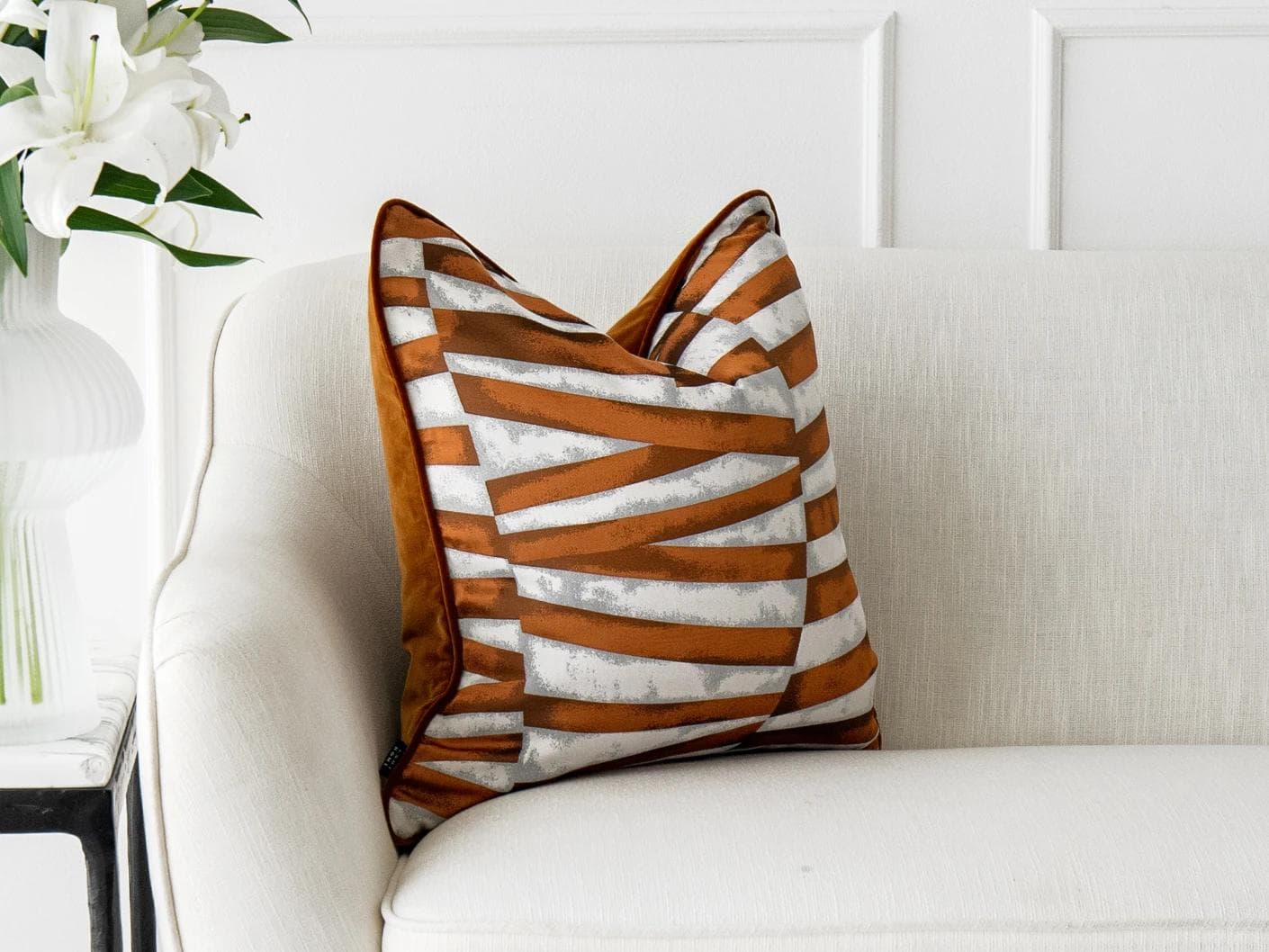 Carlie Hodler cushion in orange and white, shown in a lifestyle left view as image 4