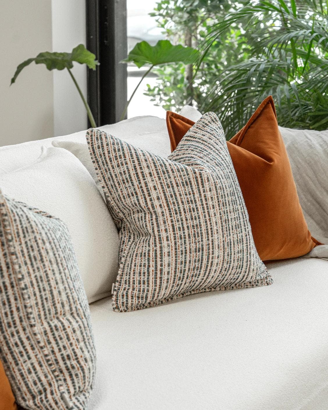 Cashwin Bundle cushion in cream and rust, shown in a lifestyle left view as image 5