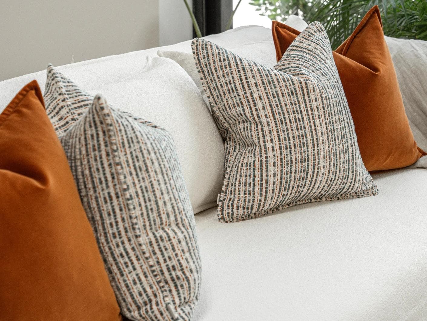 Cashwin Bundle cushion in cream and rust, shown in a lifestyle left view as image 5