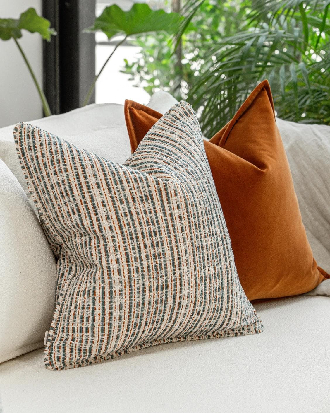 Cashwin Bundle cushion in cream and rust, shown in a lifestyle left view as image 6