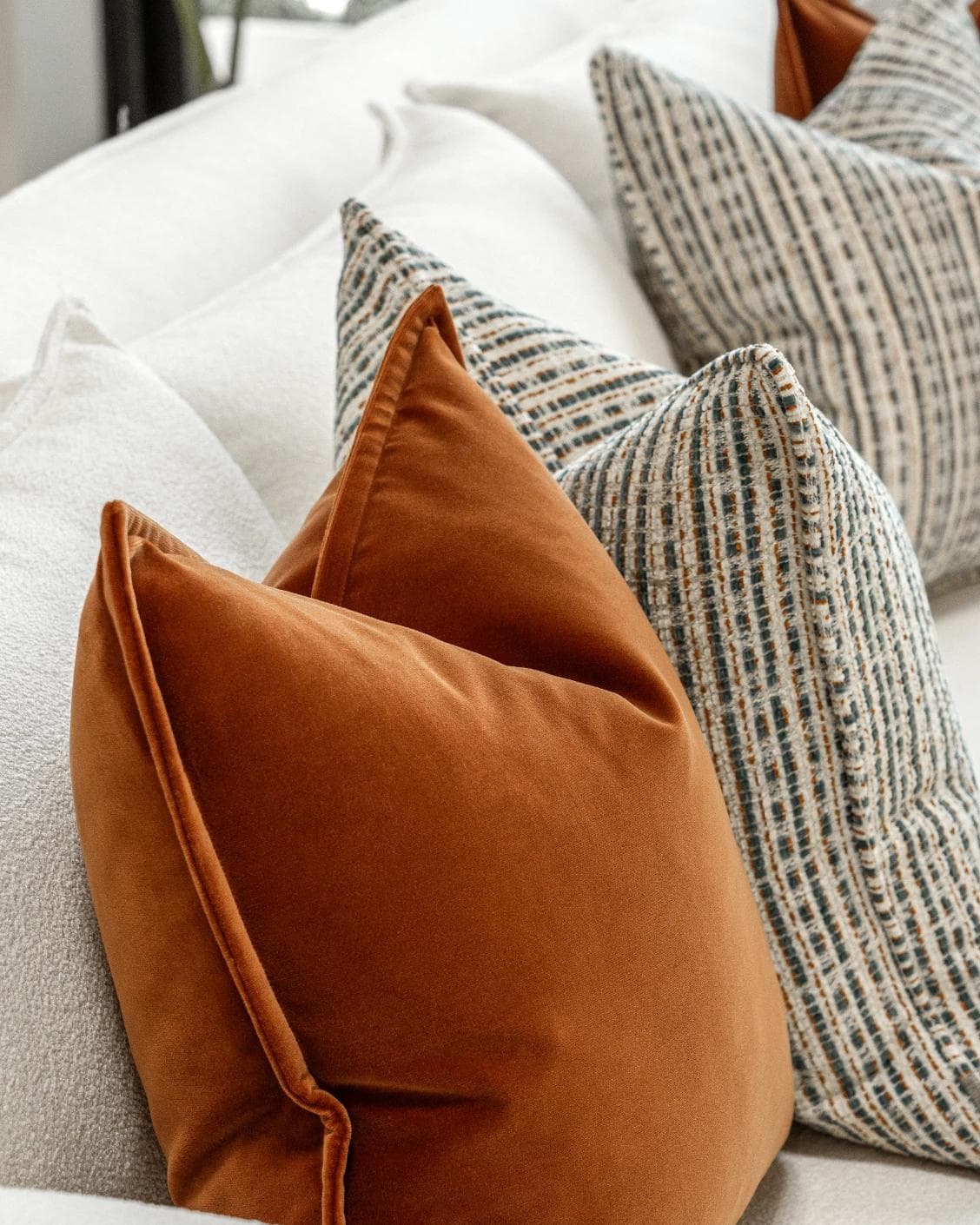 Cashwin Bundle cushion in cream and rust, shown in a lifestyle left view as image 7