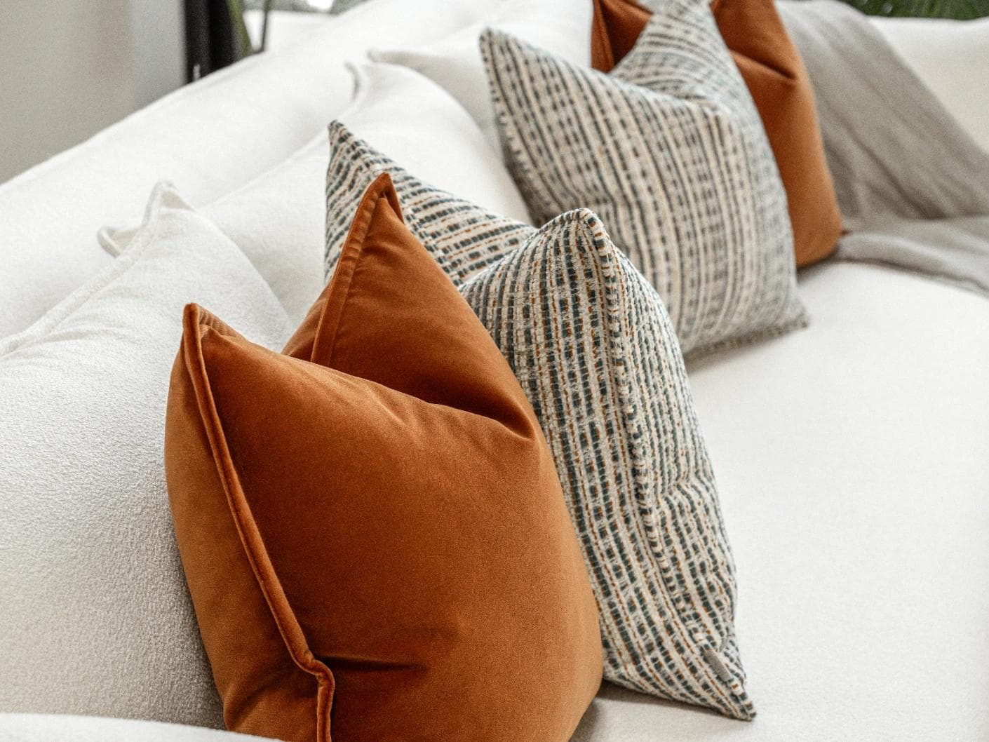Cashwin Bundle cushion in cream and rust, shown in a lifestyle left view as image 7