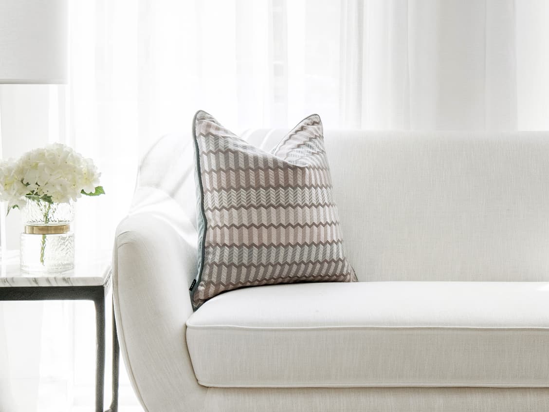 Cecilia Canova cushion in silver, blue and multicolour, shown in a lifestyle left view as image 1