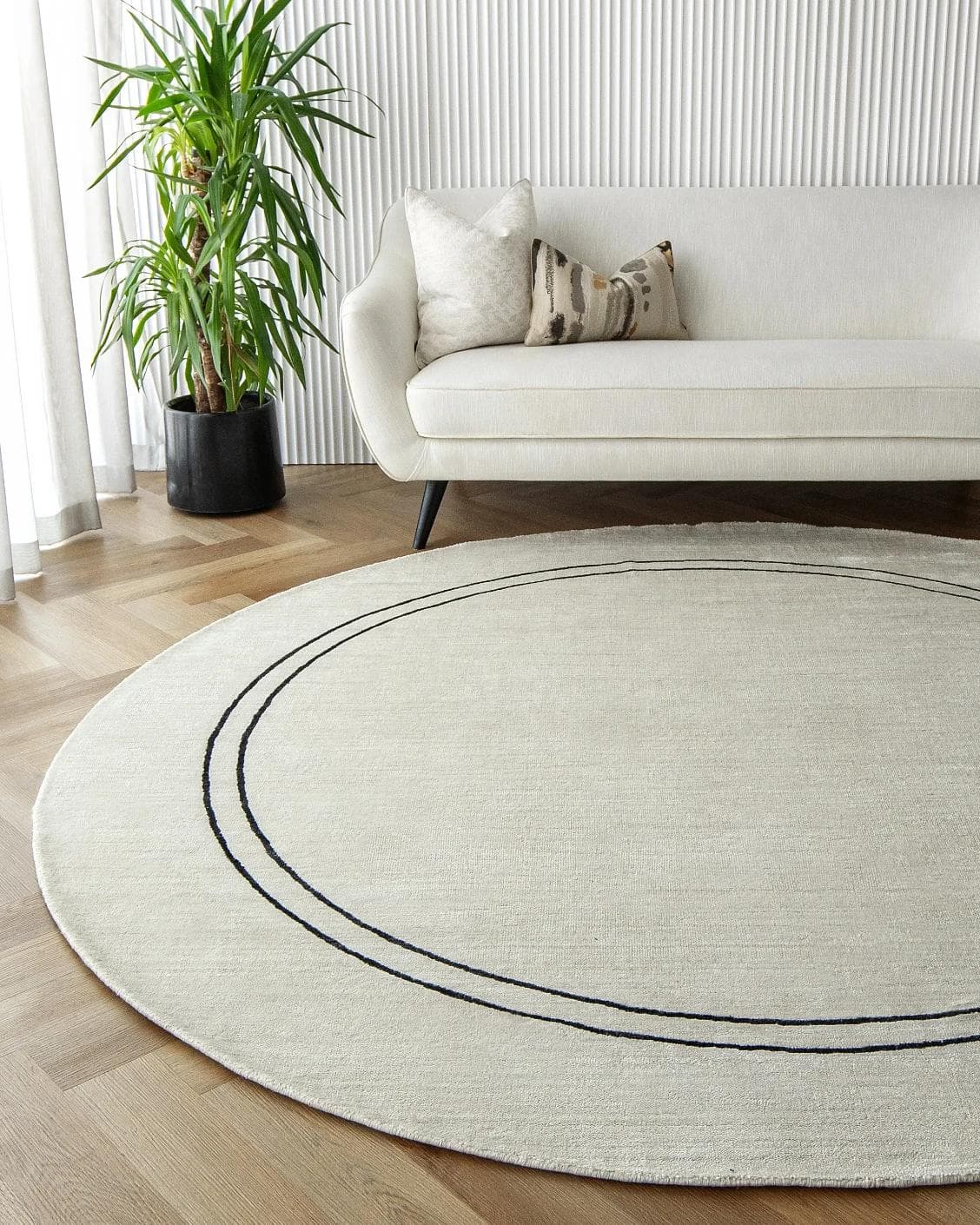 Colin Bianca Round carpet in white, black and pearl, shown in a lifestyle front view