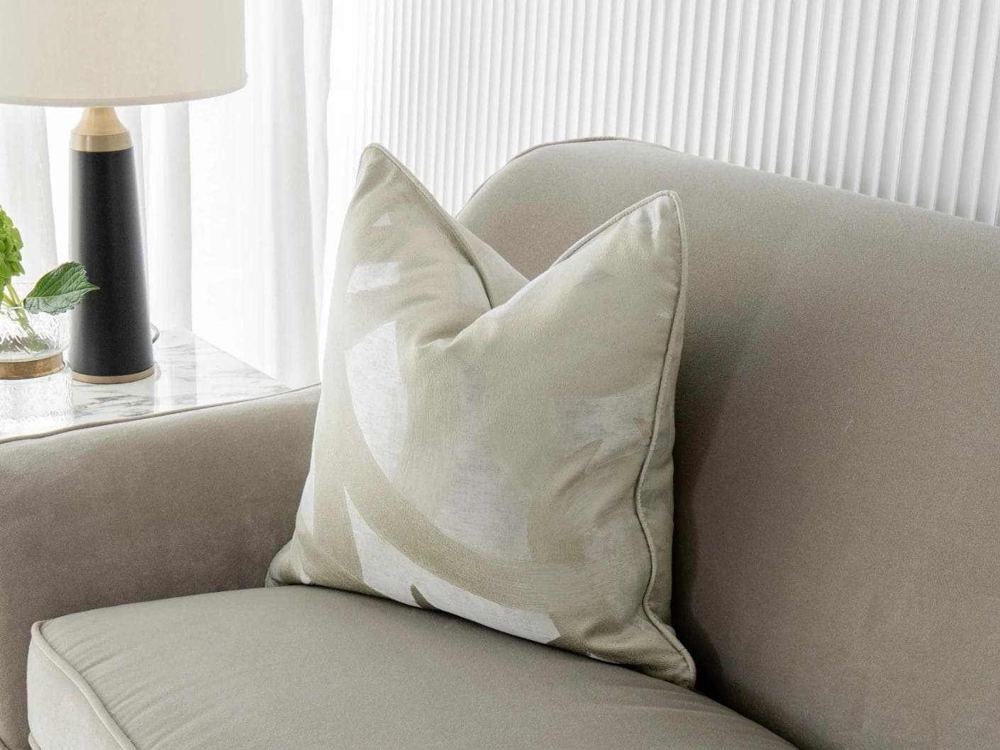 Danya Laurent cushion in silver and beige, shown in a lifestyle front view as image 2