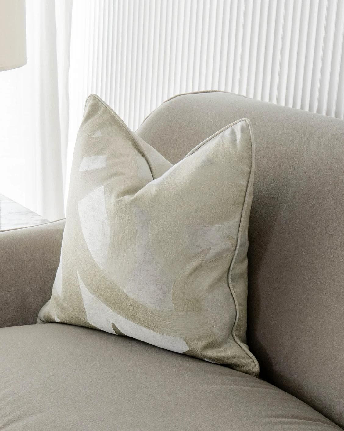 Danya Laurent cushion in silver and beige, shown in a lifestyle front view as image 2