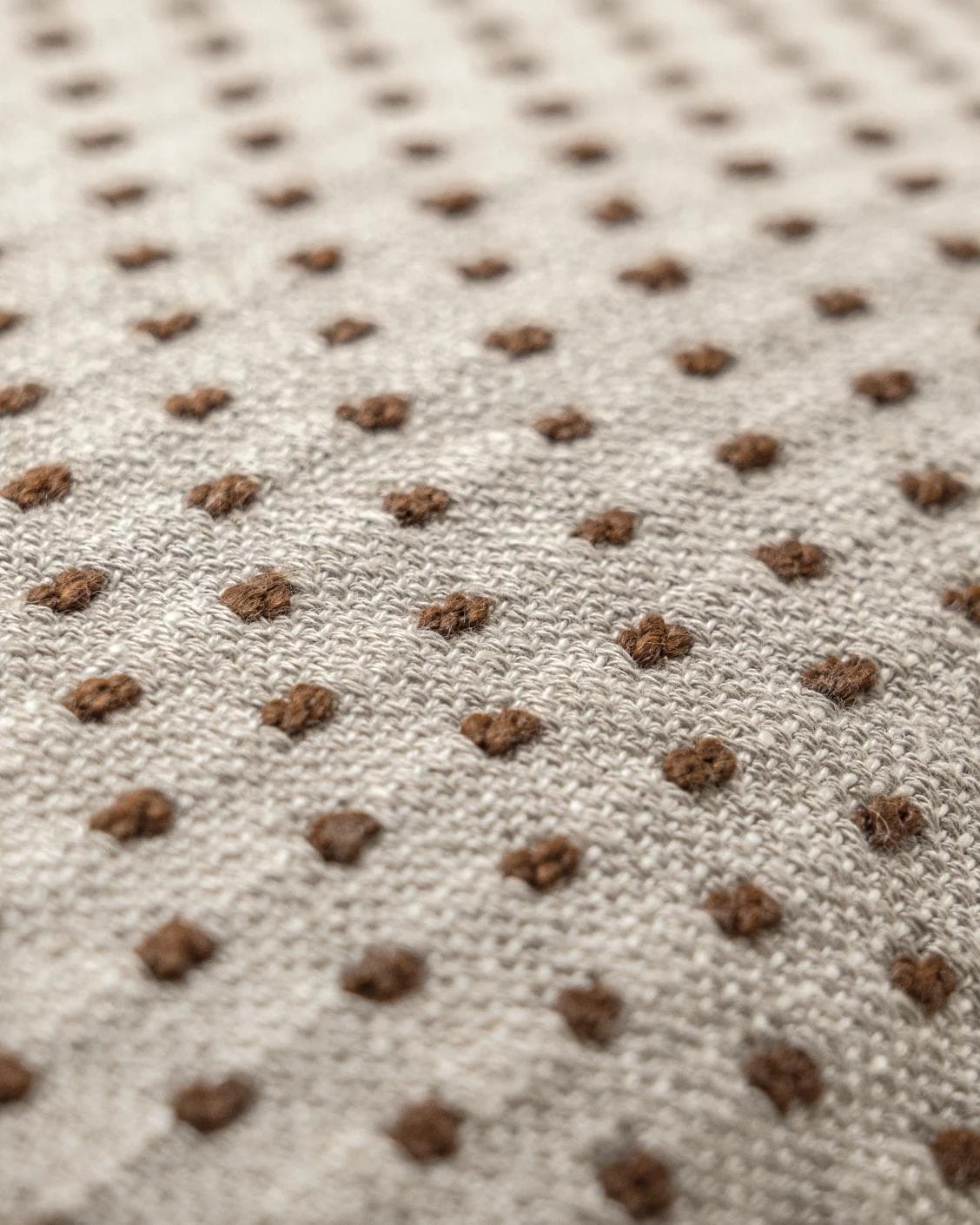 Dotty Rust cushion in beige, shown in a product close-up as image 6