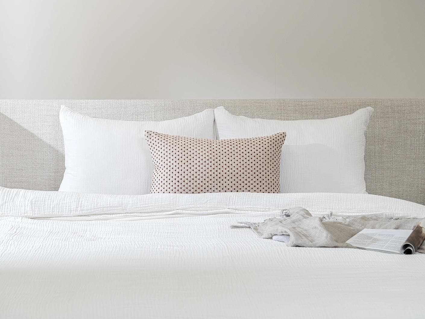 Dotty Rust III cushion in beige and grey, shown in a lifestyle front view as image 2