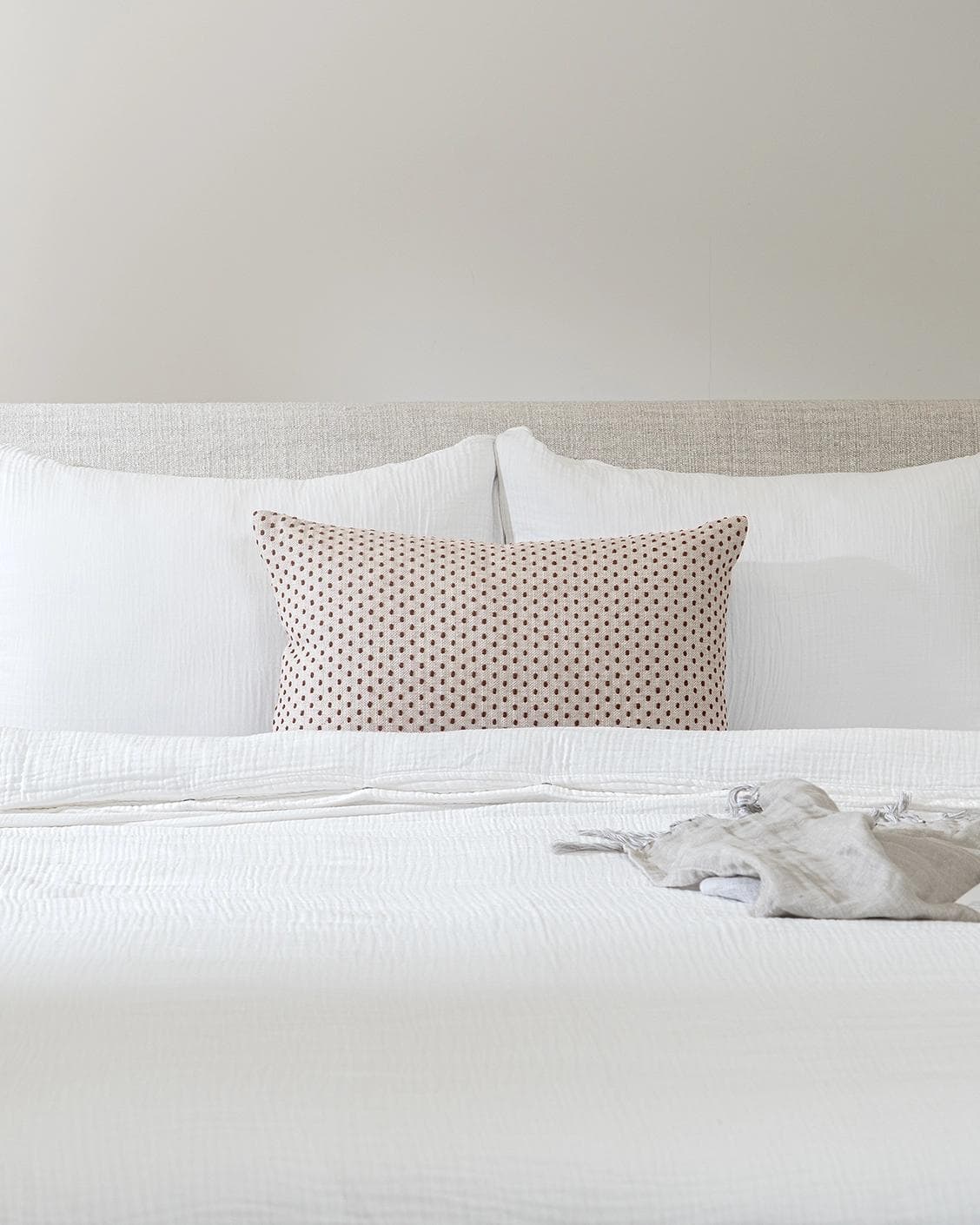 Dotty Rust III cushion in beige and grey, shown in a lifestyle front view as image 2