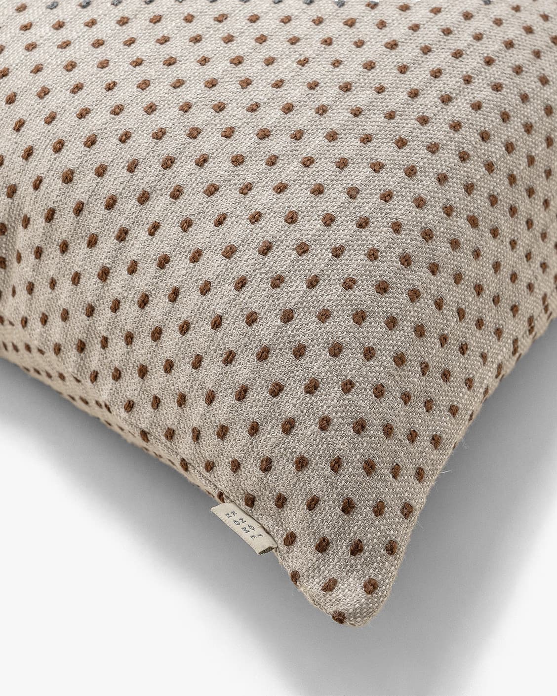 Dotty Rust III cushion in beige and grey, shown in a product close-up top view as image 4