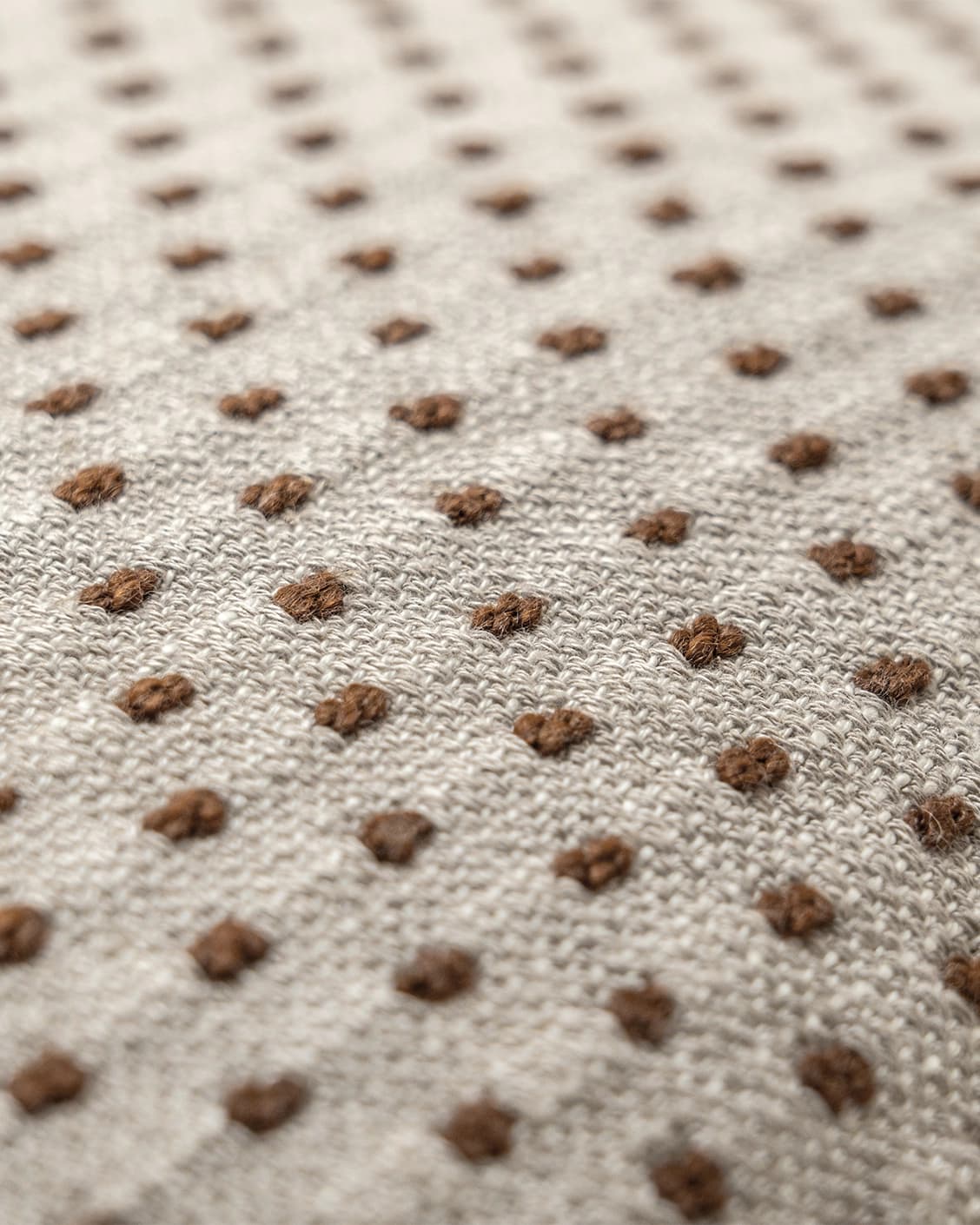 Dotty Rust III cushion in beige and grey, shown in a product close-up top view as image 5