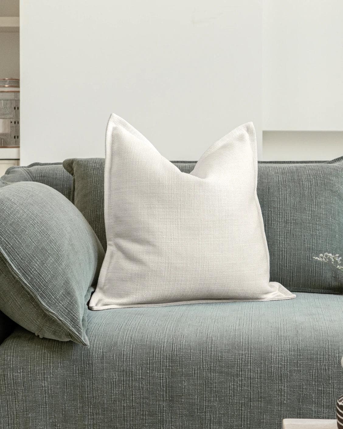 Emmett Jasmine cushion in white, shown in a lifestyle front view as image 2