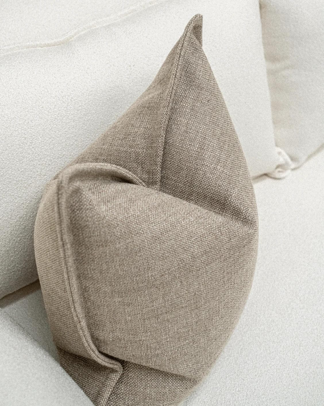 Emmett Quell cushion in taupe and grey, shown in a lifestyle top view as image 5