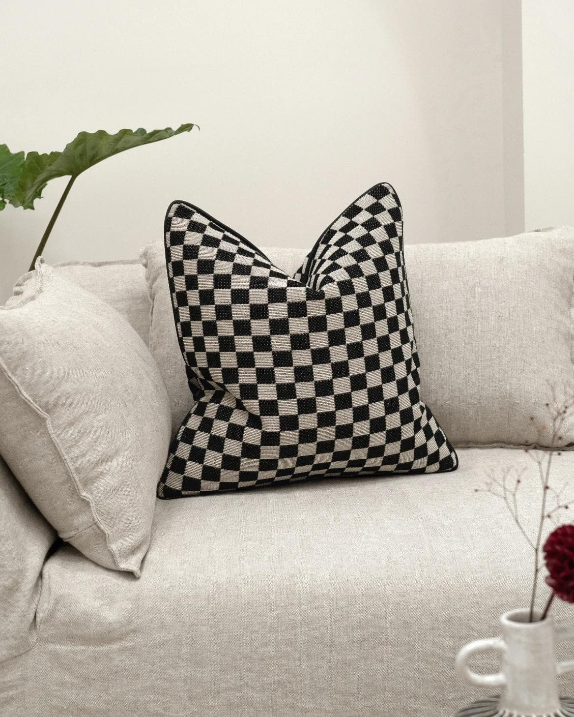 Enya Steele cushion in black and beige, shown in a lifestyle front view as image 2