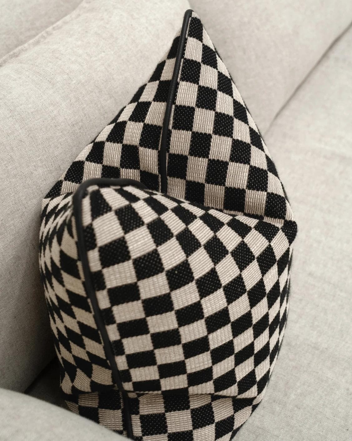 Enya Steele cushion in black and beige, shown in a lifestyle top view as image 5