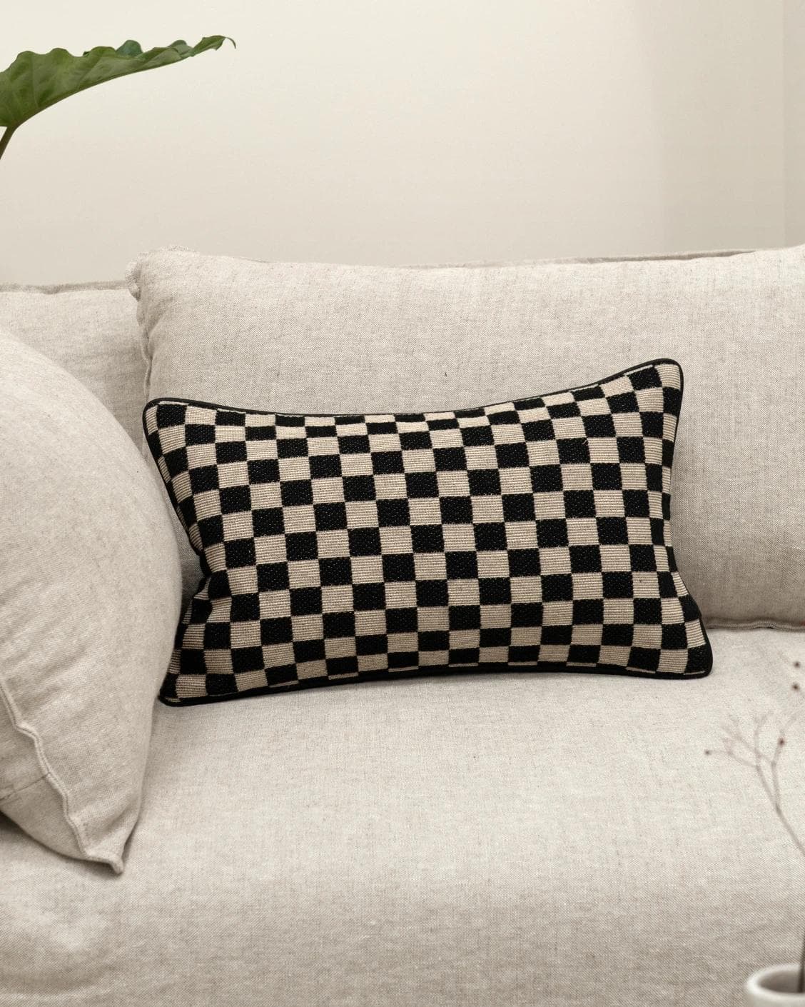 Enya Steele II cushion in black and beige, shown in a lifestyle front view as image 2