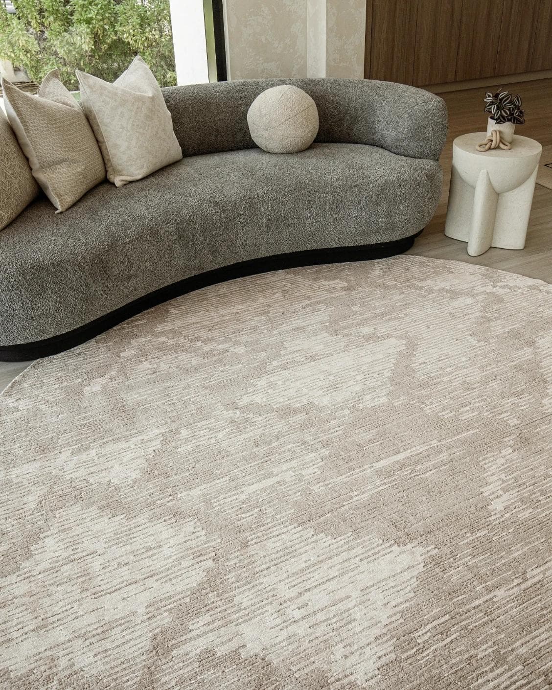 Freida Sandy Round carpet in beige, shown in a lifestyle front view