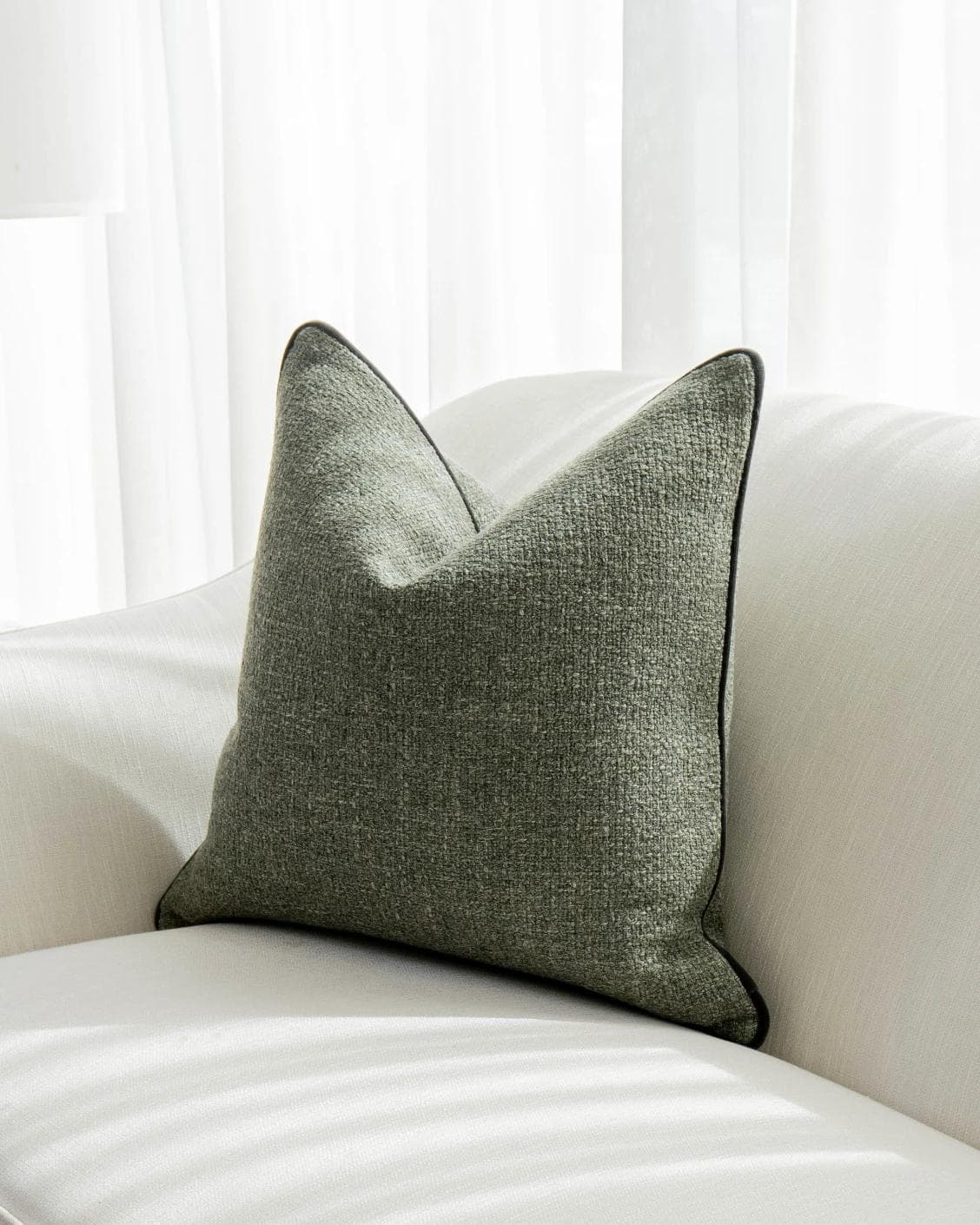 Harrison Sage cushion in green, shown in a lifestyle front view as image 2