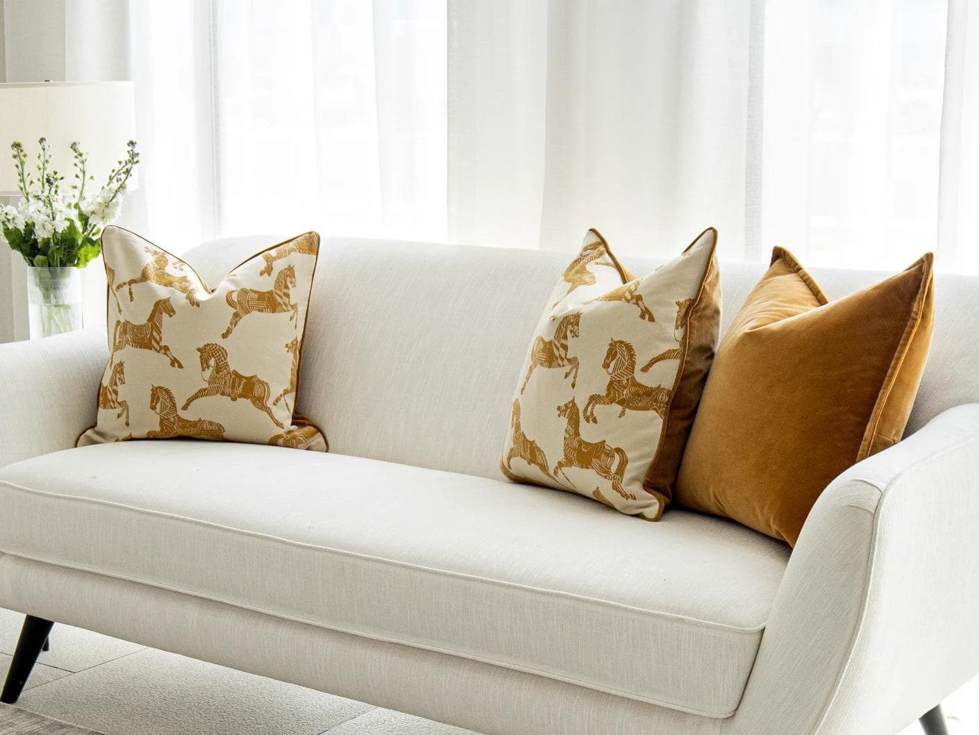 Arie Bundle cushion in orange and beige, shown in a lifestyle right view as image 2