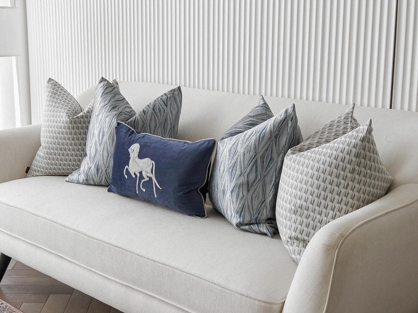 Edwin Bundle cushion in blue, silver and white, shown in a lifestyle right view as image 2