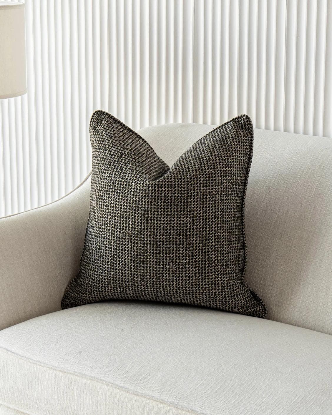 Hugo Steele cushion in black, shown in a lifestyle front view as image 2