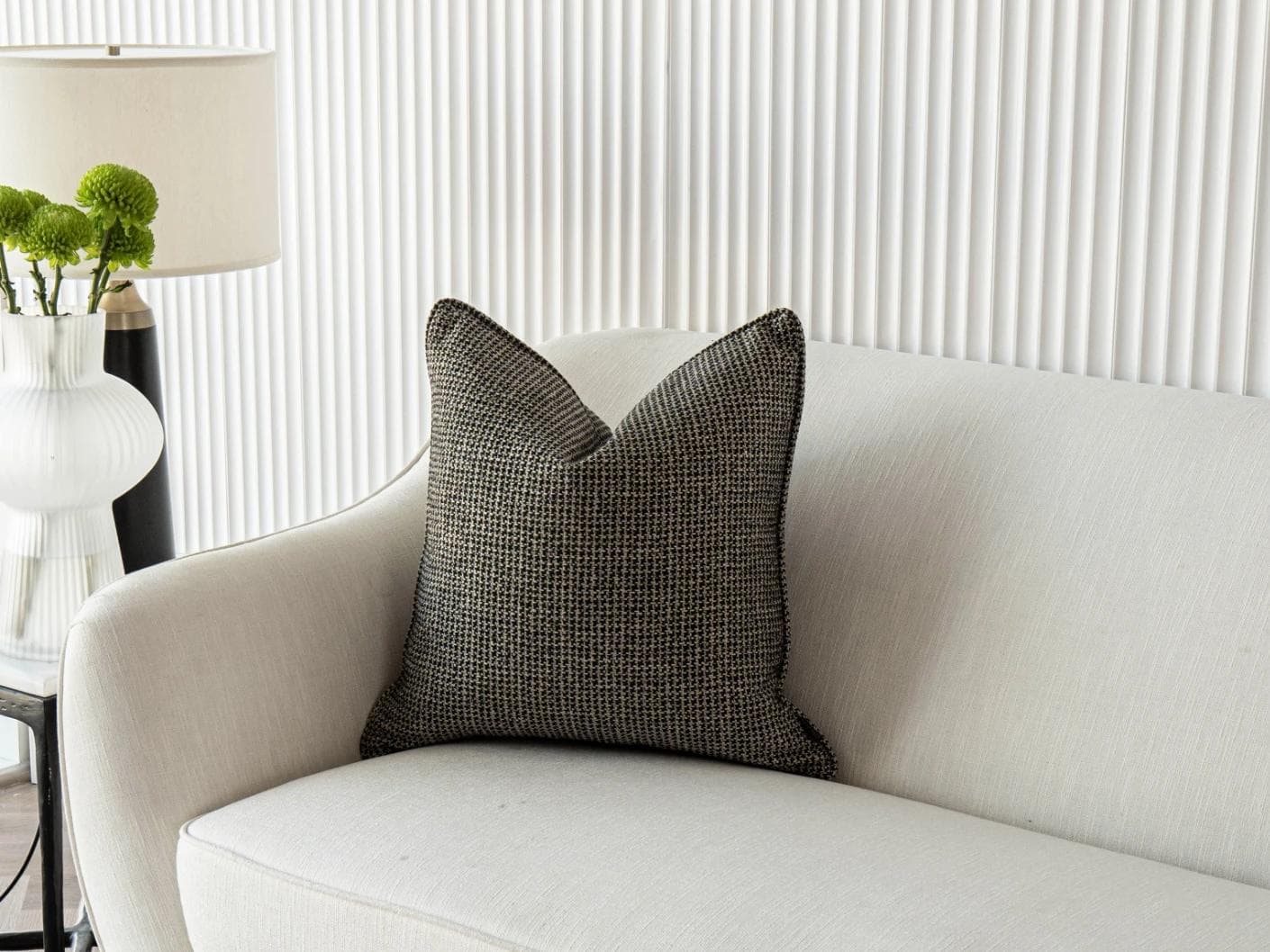 Hugo Steele cushion in black, shown in a lifestyle front view as image 2