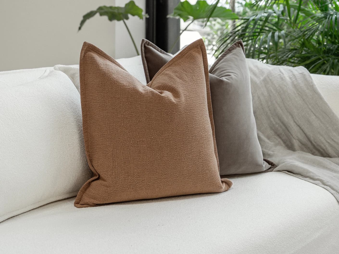 Abhishek Bundle bundle cushions in brown and rust, shown in a lifestyle front view