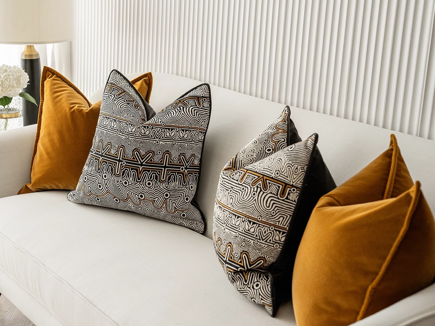 Adin Bundle bundle cushions in orange, black and silver, shown in a lifestyle front view