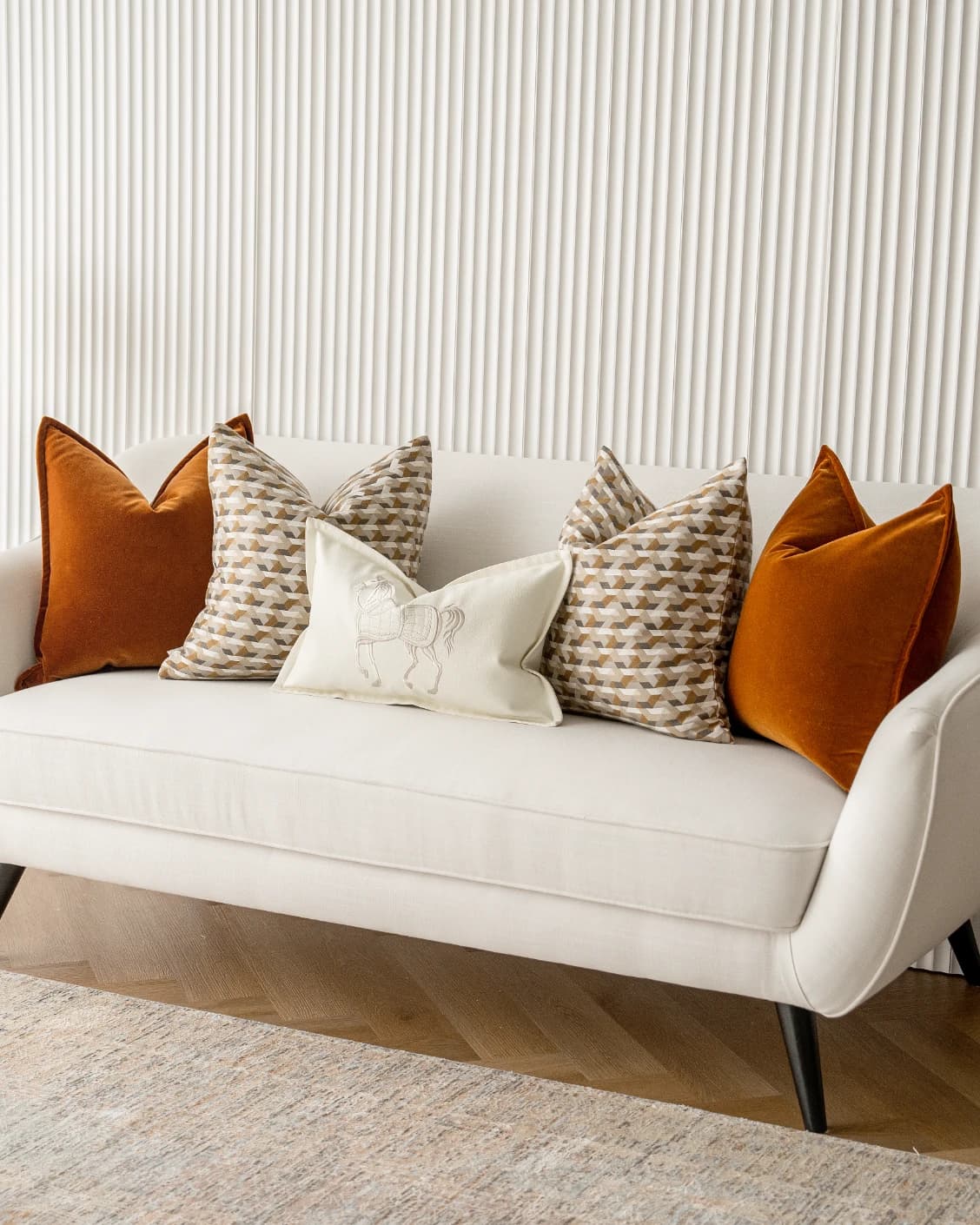 Adira Bundle cushion in rust, orange, beige and white, shown in a lifestyle front view as image 2