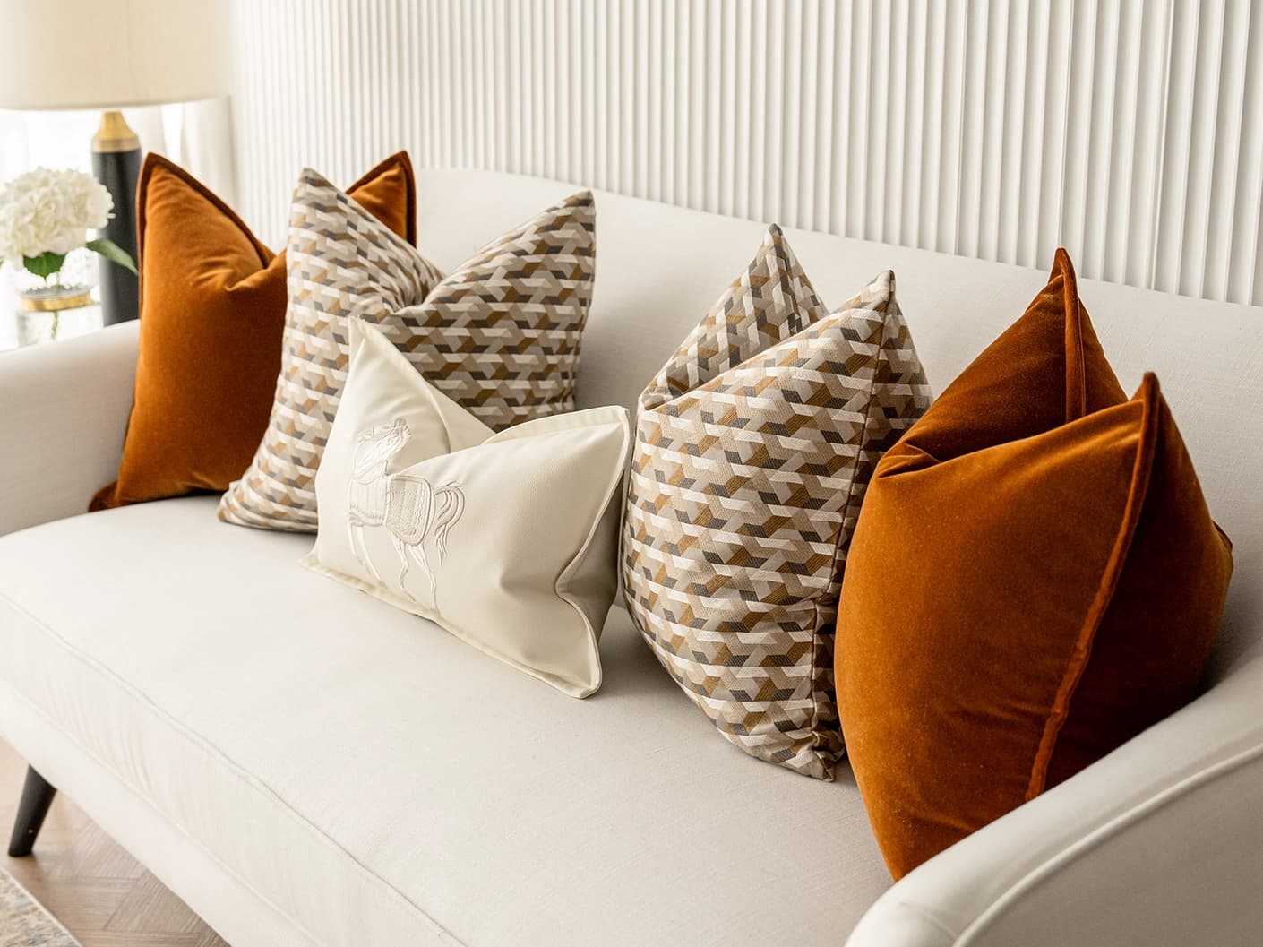 Adira Bundle bundle cushions in rust, orange, beige and white, shown in a lifestyle front view